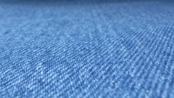 蓝色斜纹棉布的宏观照片 牛仔裤裤子上的专业工缝 临时磨损 磨损的材料 纺织品服装的复古质感表面 滑翔机娃娃极端特写镜头 — 图库视频影像