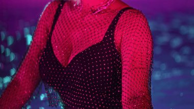 Havuz suyu partisinde, neon ışıklı ışıklar altında dans eden tanınmayacak kadar çekici bir kadın. Parlak seksi kıyafet ve takılar. Yüksek kalite fotoğraf