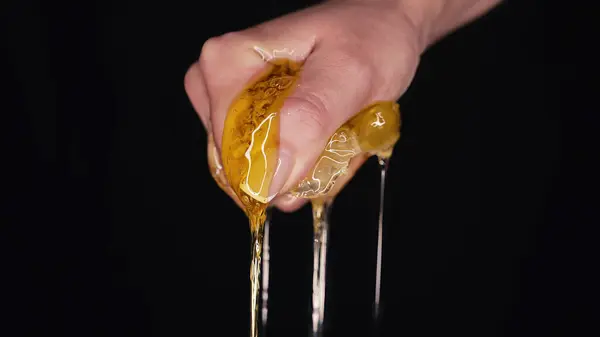Woman hand squeezes honeycombs full of honey. Dripping,pouring tasty sweet fluid. High quality photo