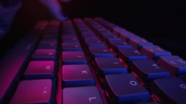 Süper makro kadın bilgisayarda RGB klavye tuşlarına neon ışıkla basıyor. Gece çalışıyorum. Siber sporcu kadın. Yüksek kalite 4k görüntü