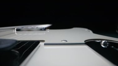 Elektro gitar panosundaki iplerin kaydırıcı makrosu. Cihazın ayrıntıları. Müzik, ses, sanat arka planı. Yüksek kalite 4k görüntü