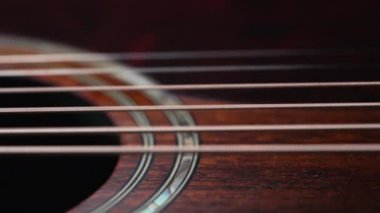 Titreşen akustik gitar telleri. Klasik müzik enstrümanı çalıyor. Ses dalgaları, tıngırdayan akorlar, ses rezonansı. Süper makro kaydırıcı. Yüksek kalite 4k görüntü