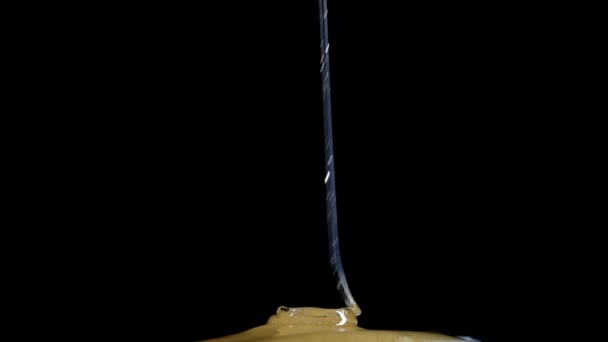 ハニーは黒い背景に注がれている ゴールデンネクタードリッピング 厚い甘いドロップ クローズアップビュー Apiary 養蜂コンセプト デザートを調理する 高品質の4K映像 — ストック動画