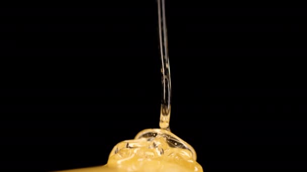 蜂蜜甜花流淌在黑色的背景上 黄金液体花蜜流动 厚重的甜滴宏观视图 健康的糖浆 美味的食物 高质量的4K镜头 — 图库视频影像