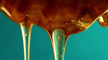 Organik bal, zeytinyağı kaşığından akar. Lezzetli bir işlem. Apiary, arıcılık konsepti. Damlayan, tatlı sıvı nektarı yavaş çekimde döken. Yüksek kalite 4k görüntü