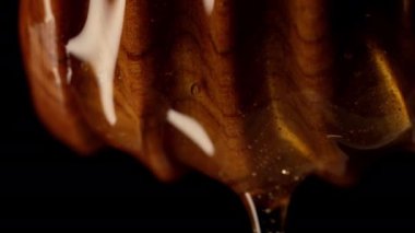 Organik bal, zeytinyağı kaşığından akar. Lezzetli bir işlem. Apiary, arıcılık konsepti. Damlayan, tatlı sıvı nektarı yavaş çekimde döken. Yüksek kalite 4k görüntü