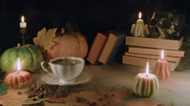 Balkabağı mumlarının arasında porselen kahve fincanı. Sonbahar temalı içerik, kafe promosyonları ya da rahatlatıcı görsel hikaye anlatımı. Samimiyet, huzur ve davetkar atmosfer.. 