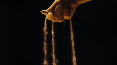 Cazibe, sembolizmle buluşur. Zamanın kumlarını yöneten altın parıldayan ellerin büyüsü. Akan kum zamanın amansız geçişini sembolize eder. Yüksek kalite 4k görüntü