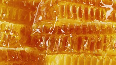 Saf altın bal iksiriyle işlenmemiş bal petekleri. İnanılmaz lezzetli akış. Makro doku, çiçek nektarının yapısı. Tatlı görüntüler, çarpıcı detaylar. Yüksek kalite