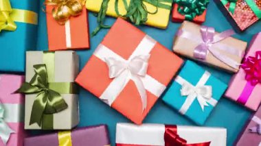 Mavi arka planda dönen hediye kutuları. Yaratıcı projeler ve reklamlar için hareketli animasyonları durdurun. Kutlama ruhu, hediyeler, tatiller. Güzel paketlenmiş sürprizler. 4k görüntü