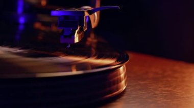 Tonearm vinil pikabın üstüne düştü. İnsan analog sesten zevk almak için müziği açar. Hipnotik disk dönüşü. Sonsuz sinematik cazibe. Audiophile meraklıları. Yüksek kalite 4k görüntü
