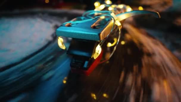 ビニールレコードプレーヤーのクリスマスガーランドライト付きのトーンアーム 雪でディスカッション ウィンターシーズンの魅惑 高品質の4K映像 — ストック動画