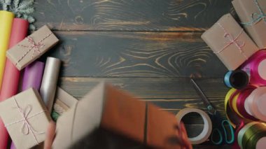 Noel Baba, erkek eli hediye kutusunu tahta masaya koyar. Sanatsal estetik, Noel zamanı. Üst manzara, şenlikli zemin. Görsel hikaye anlatımı. Yüksek kalite 4k görüntü