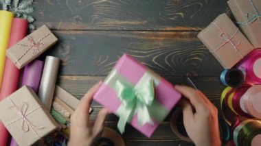 Hediye ambalajlayan adam ellerini güzel bir şekilde kadınlara veriyor. Üst Manzara. Hediye almak, tebrikler. Stüdyo dekorasyonları. Yüksek kalite 4k görüntü