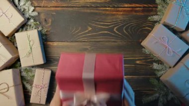 Noel Baba, erkek eli hediye kutusunu tahta masaya koyar. Sanatsal estetik, Noel zamanı. Üst manzara, şenlikli zemin. Görsel hikaye anlatımı. Yüksek kalite 4k görüntü