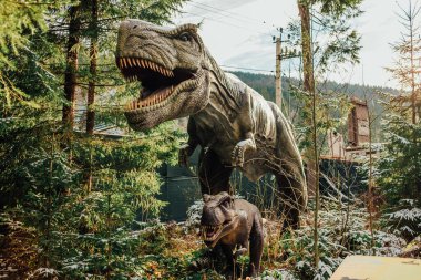 Bukovel, Ukrayna - Aralık 2023. Dinopark 'taki dinozorların cazibe heykeli, doğadaki kışlık orman parkı. Çocuklar ve yetişkinler için modern bir sergi. Eğitim konsepti. Yüksek kalite fotoğraf