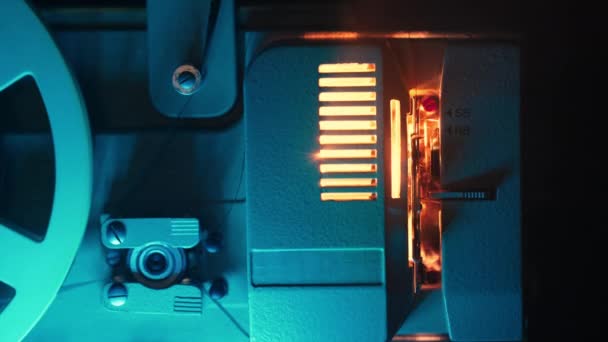 時代遅れのフィルムプロジェクター レトロホームシアターエンターテイメント ノスタルジア 思い出 ビームライトの暖かい光 回転リール 高品質の4K映像 — ストック動画