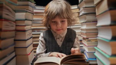 Düşünceli anaokulu yakışıklısı çocuk kütüphanede kitap sayfalarını çeviriyor. Küçük çocuk kitapçıda ya da kitapçıda okumayı seviyor. Yüksek kalite 4k görüntü