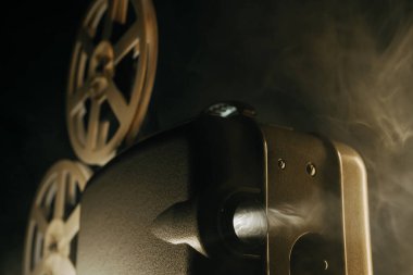 Retro projektör karanlık odada film oynuyor. Eski filmlerin zamansız titreşimleri. Eski nesneler, sinema, Hollywood konsepti. Festival geçmişi ve yayın ekipmanları için mükemmel. Yüksek kalite 