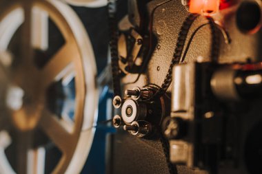 Retro projektör karanlık odada film oynuyor. Eski filmlerin zamansız titreşimleri. Eski nesneler, sinema, Hollywood konsepti. Festival geçmişi ve yayın ekipmanları için mükemmel. Yüksek kalite