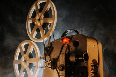 Retro projektör karanlık odada film oynuyor. Eski filmlerin zamansız titreşimleri. Eski nesneler, sinema, Hollywood konsepti. Festival geçmişi ve yayın ekipmanları için mükemmel. Yüksek kalite