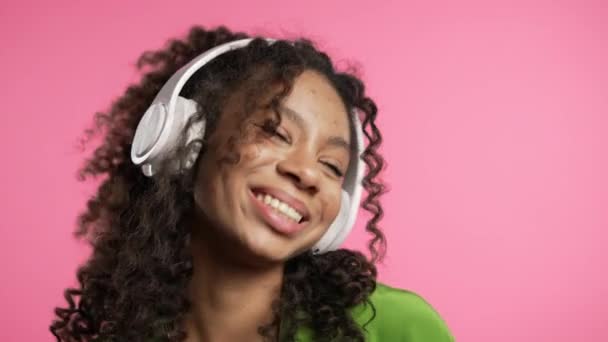 Mujer Afroamericana Escuchando Música Disfrutando Bailando Con Auriculares Rosa Generación — Vídeos de Stock
