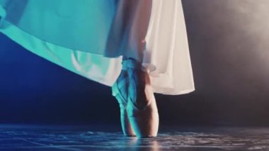 Bale dansçılarının bacakları mavi ışıkta sahnede. Kadın alıştırma yapıyor. Ayakkabılı balerin ayakları. Tanımlanamayan profesyonel bayan klasik pas gösteriyor. Yüksek kalite 4k görüntü