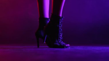 Neon Smoky stüdyosunda topuklu giyen bir kadın. Seksi ince bacaklı kız. Modern koreograf, kadınsı ayakkabı konsepti. Salon dansı için profesyonel yüksek topuklu ayakkabılar..