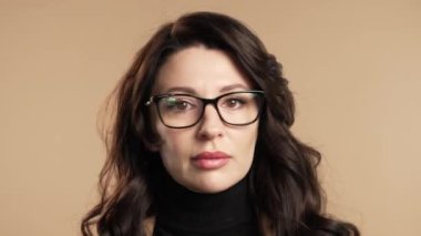 Avrupalı güzel olgun bir kadın baş işareti olmadan onaylamıyor, onaylanmayacak şekilde başını sallıyor. Reddetmek, reddetmek, anlaşmazlık bej arka planda güzel bir bayanın portresi. Yüksek kalite 4k görüntü