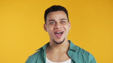 Şok adam sevindi, çığlık attı. İlgi çekmeye çalışan etkileyici bir adam. Satış konsepti, karlı bir teklif. Sarı arka planda heyecanlı bir mutluluk. Yüksek kalite 4k