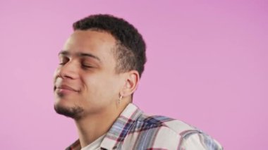 Aktif pozitif esmer adam pembe arka planda dans ediyor. Komik mutlu adam, harika bir gün. Yüksek kalite 4k görüntü