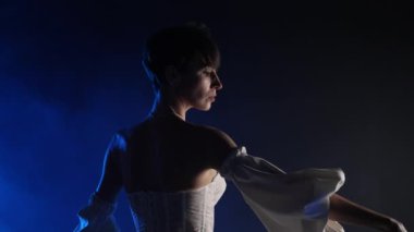 Beyaz ipek elbiseli kibar kadın bale kolları koreografisi yapıyor. Neon stüdyoda elleri ile çağdaş tarz dans ediyor. Yüksek kalite 4k görüntü