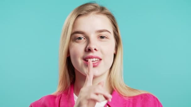 Gülümseyen Amerikalı Kadın Parmaklarını Dudaklarında Tutuyor Mavi Stüdyo Arka Planı — Stok video