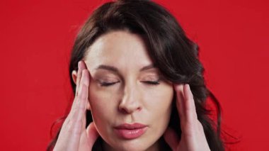 Kafası karışmış olgun bir kadın, hayır, unuttu. Şok olmuş iş kadını üzüntü, pişmanlık, drama, başarısızlık, kırmızı arka planda sorunlar yaşıyor. Yüz bakımı. Yüksek kalite 4k