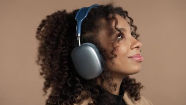 Šťastná Afroameričanka Sjíždí Poslouchá Hudbu Užívá Tance Sluchátky Béžovém Studiovém — Stock video
