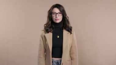 İlgisiz olgun bir bayan el işaretini onaylamıyor. İnkar etmek, reddetmek, katılmamak. Bej arka planda orta yaşlı kadın portresi, mola kavramı. Yüksek kalite 4k