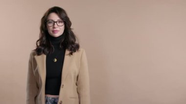 Gülümseyen iş kadını reklamınız için boş bir yer arıyor. Doğru tarafı gösteren olgun bir kadın öneriliyor, kopyalama alanı. Kadın, bej arka planda izole edilmiş bir şey sunuyor. Yüksek kalite