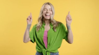 Güzel, 30 'lu yaşlarda eğlenen, en sevdiği müziği çalan, gülümseyen, sarı arka planda dans eden güzel bir kadın. Müzik, dans konsepti, 4k