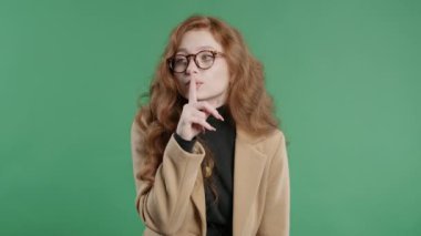 Güzel, şık bir ofis çalışanı, parmaklarını dudaklarında tutan, yeşil stüdyo geçmişi olan. Sessiz olun, sessiz olun, komplo kurun, dedikodu yapın, dedikodu yapın. Yüksek kalite 4k