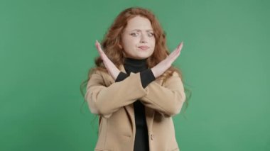 Hayır, asla, güzel, kızıl öğrenci bir kadın el işaretini keserek jestten hoşlanmaz ve reddeder. Onaylamayan ciddi bir kız olumsuzluk işareti yapıyor.