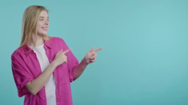Gülümseyen sarışın bayan reklamınız için boş bir yer arıyor. Önerilen kadın sağ tarafı işaret ediyor, boşluğu kopyalayın. Kadın, mavi arka planda izole edilmiş bir şey sunuyor. Yüksek kalite 4k