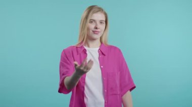 Genç ve güzel bir kadın ona eşlik etmek istiyor. Davetkar bir şekilde el ele sarılma hareketi yapıyor. Genç bayan arıyor - Hey sen, buraya gel. Oyuncu, davetkar. Mavi stüdyo arka planı