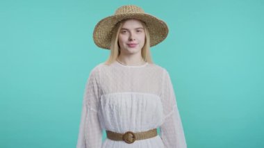 Boho elbisesi içinde güzel bir kadın evet işareti veriyor, başını sallıyor, onaylıyor. Olumlu gülümseyen Avrupalı kadın, vücut dili. Doğru mükemmel seçim, harika bir anlaşma. Mavi stüdyo arka planı.