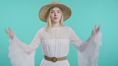 Kafası karışmış şık bir kadın, omuzları kalkık. Yardımcı olamıyor, bir jest yapıyor. Bilmiyorum. Zor soru, suçlu tepkisi, şaşkın genç kız mavi arka planda. Yüksek kalite 4k