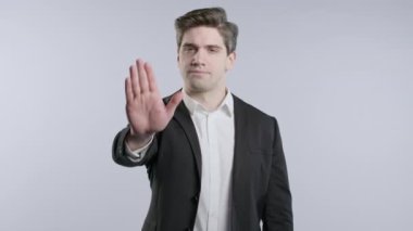 Ciddi bir Avrupalı işadamı dur işareti ile reddedici bir hareket sergiliyor. Benimle oyun oynama. Patron, resmi kıyafetli lider beyaz arka planda izole edilmiş. Yüksek kalite 4k