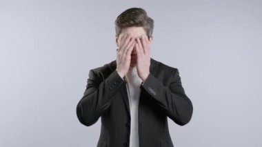 Resmi ofis kıyafetli hayal kırıklığına uğramış işadamı facepalm yapıyor. Pişmanlık, başarısızlık, tatminsizlik, zaman kaybı, ofiste sorunlar, beyaz stüdyo geçmişi. Yüksek kalite 4k