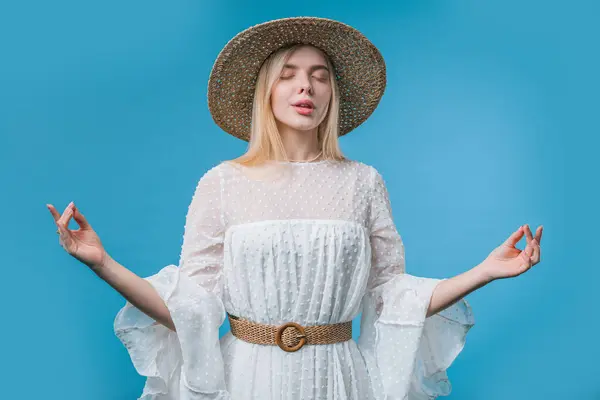 stock image Calm woman relaxing, meditating, refuses stress. Blonde lady breathes deeply, calms down blue studio background. Yoga, moral balance, zen concept. High quality