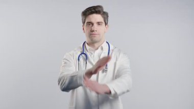 Beyaz önlüklü ciddi derecede tatminsiz bir doktor hiçbir işaret olmadan onaylamıyor, reddediyor, onaylanmayacak şekilde başını sallıyor. Reddetmek, reddetmek, anlaşmazlık, olumsuz cevap. 4k