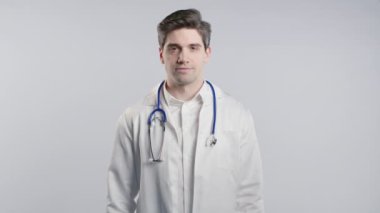 Stüdyoda 30 'lu yaşlarda beyaz önlüklü bir doktorun portresi. Hastane mesleği, Amerikan sağlık uzmanı. Yüksek kalite 4k görüntü