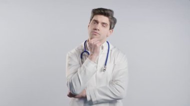 Tıp önlüğü giymiş dahi bir hekim beyaz arka planı işaret ederek 